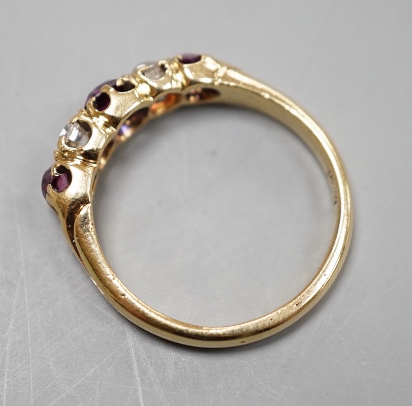 An 18ct gold, three stone ruby and two stone diamond set half hoop ring, size O, gross weight 3.7 grams.